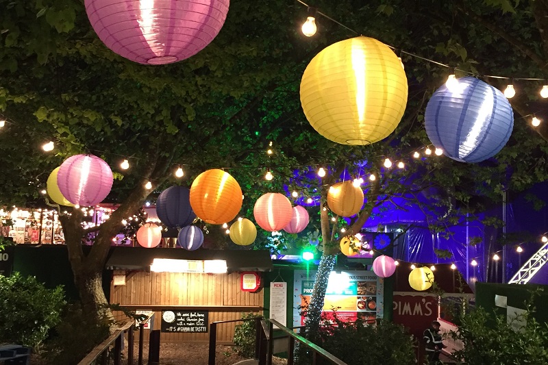 Summer Outdoor Lighting Tips Close Up of Colorful Paper Lanterns Hanging Between Trees