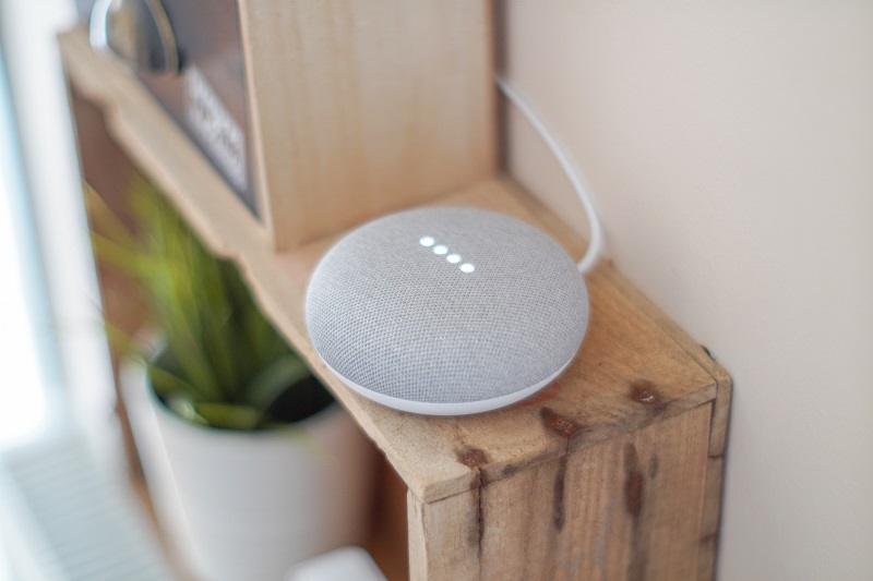 Best Smart Light Switch Options for Google Home a Google Home Mini Sitting on a Shelf in a Home